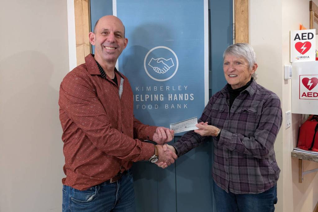 Suzanne McAllister presents a cheque for $1,500 to Kimberley Helping Hands Food Bank manager Thom Tarte. (Carol Fergus/Submitted).